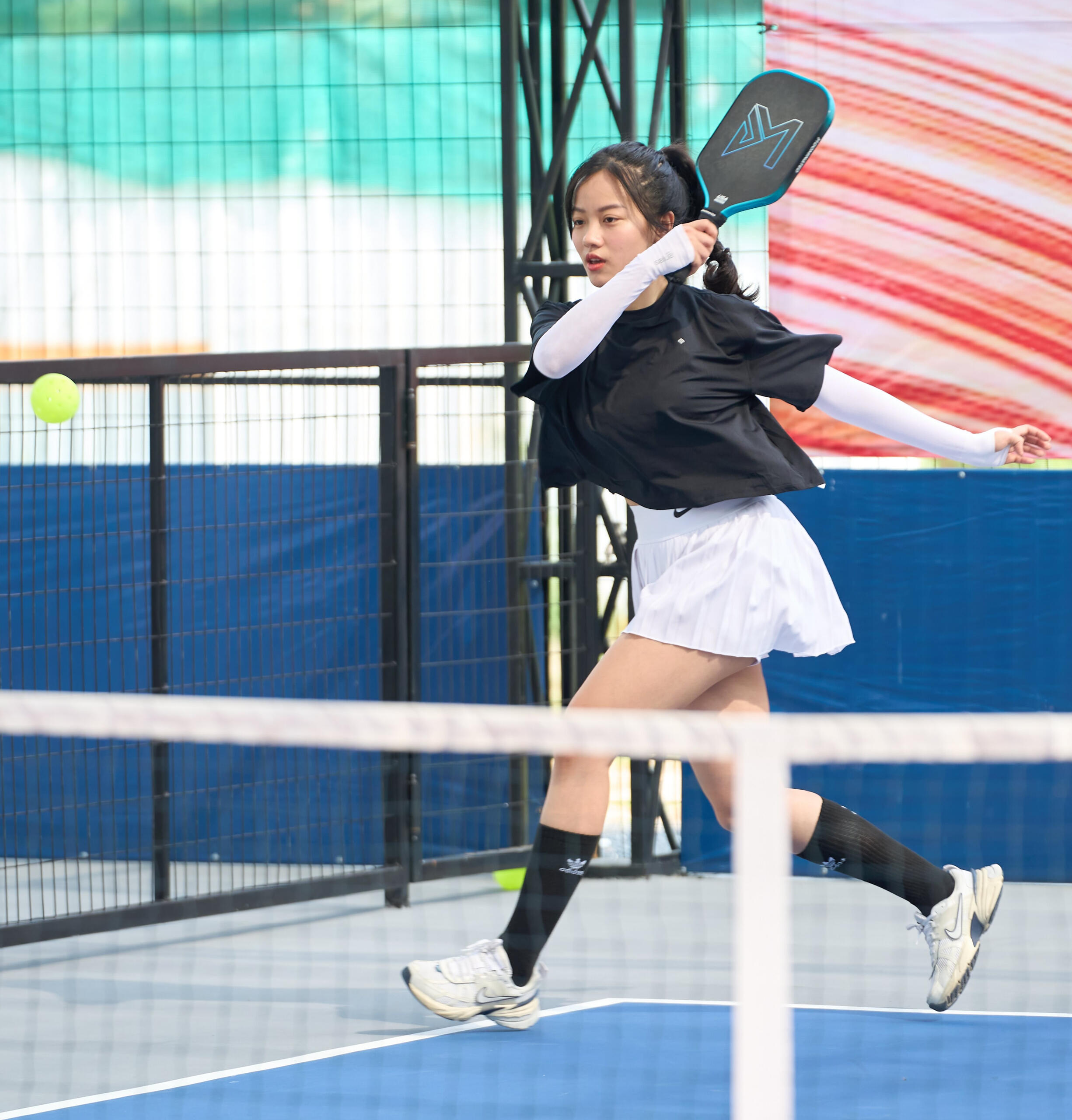 Female founder playing pickleball at Founders Pickleball Club Saigon Woman entrepreneur hitting a pickleball during a Founders Pickleball Club game in Saigon